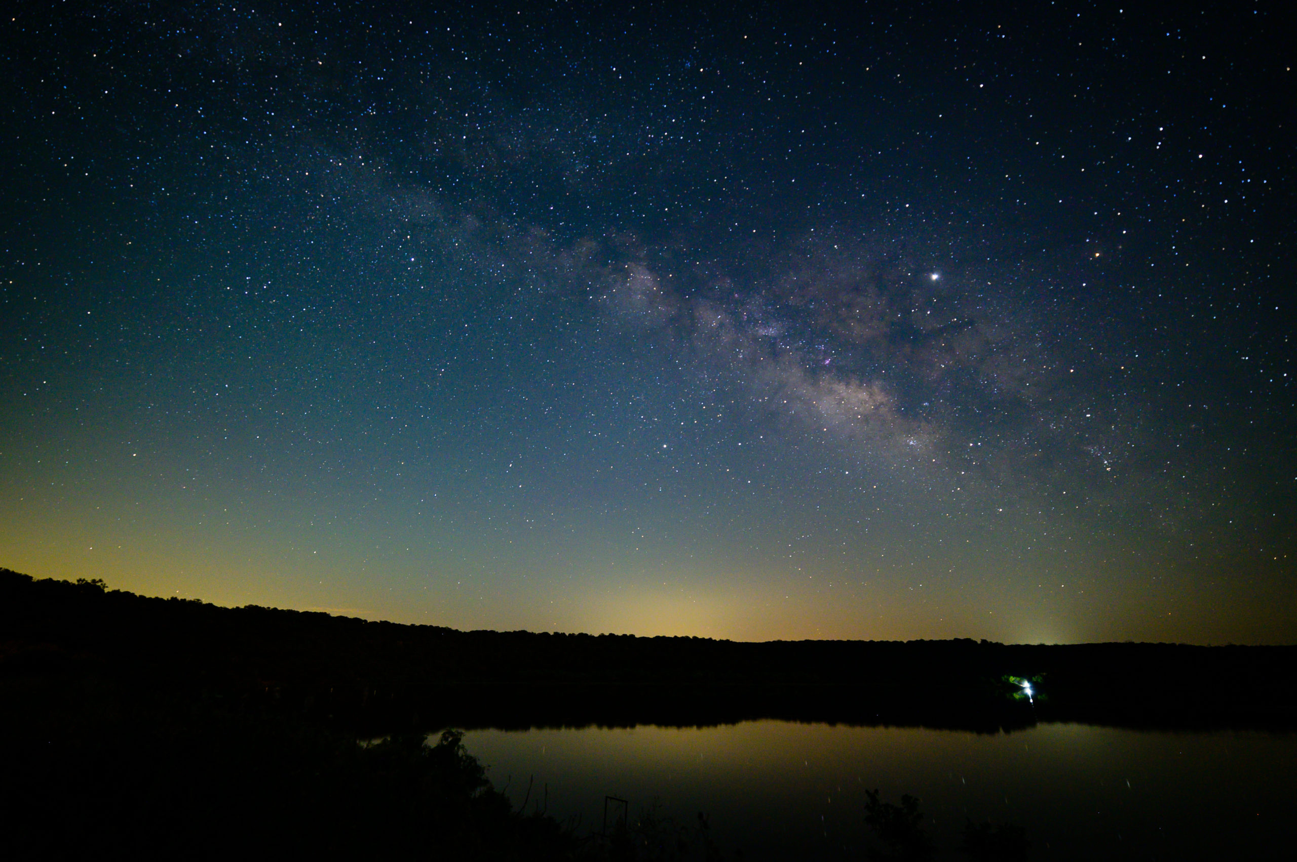 The Milky Way spans over a lake.